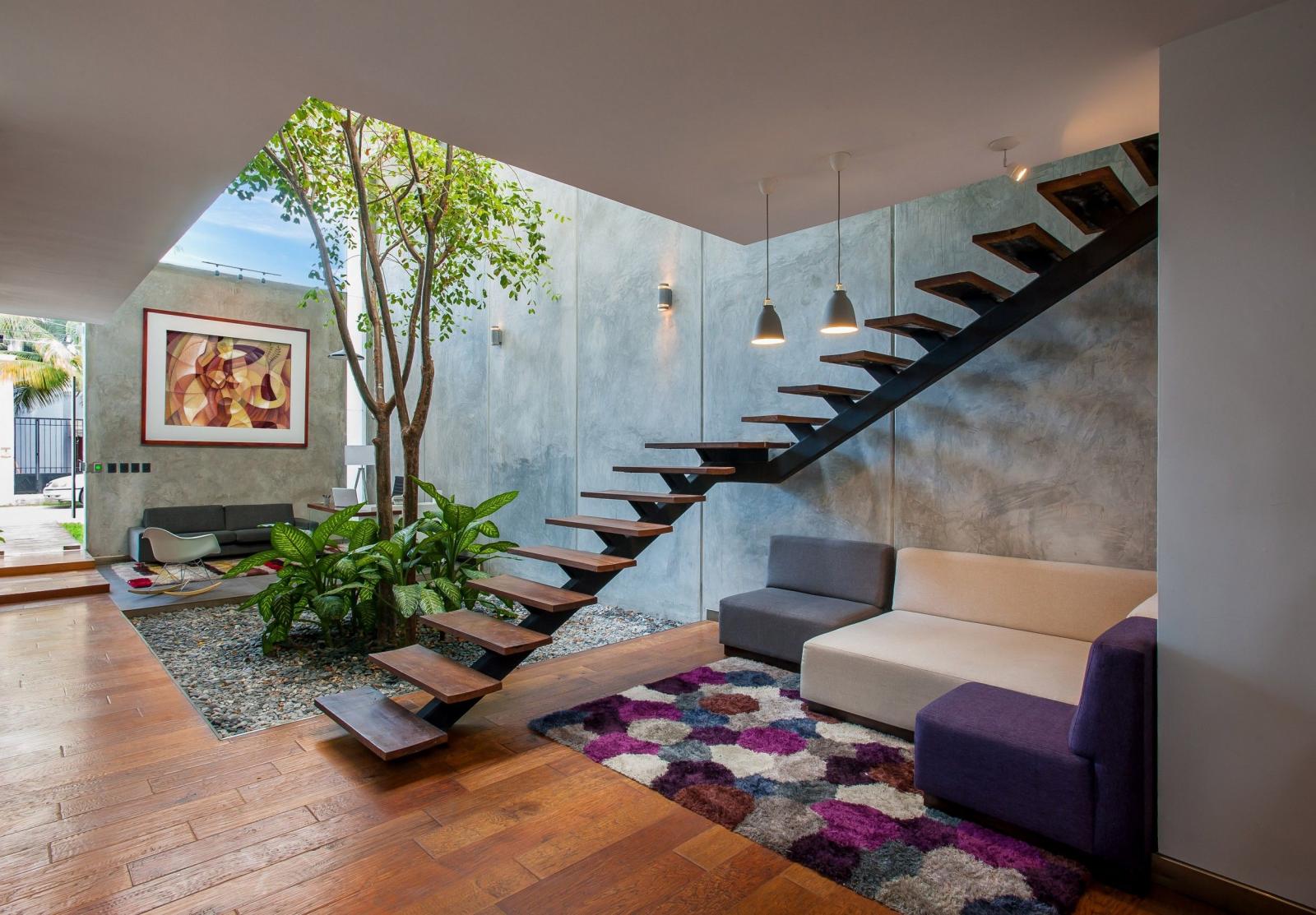 Trang trí bậc tam cấp phòng khách: Đặt một cây nhân tạo bên cạnh chiếu nghỉ của cầu thang